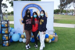 3 students wearing masks and college gear