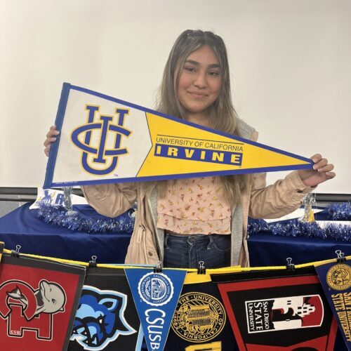 Wendy smiling and holding a UC Irvine pennant